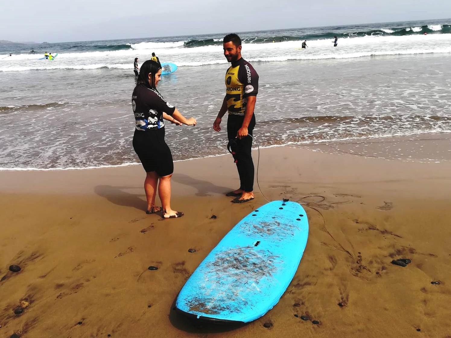 Persona con síndrome de Down y voluntario haciendo surf